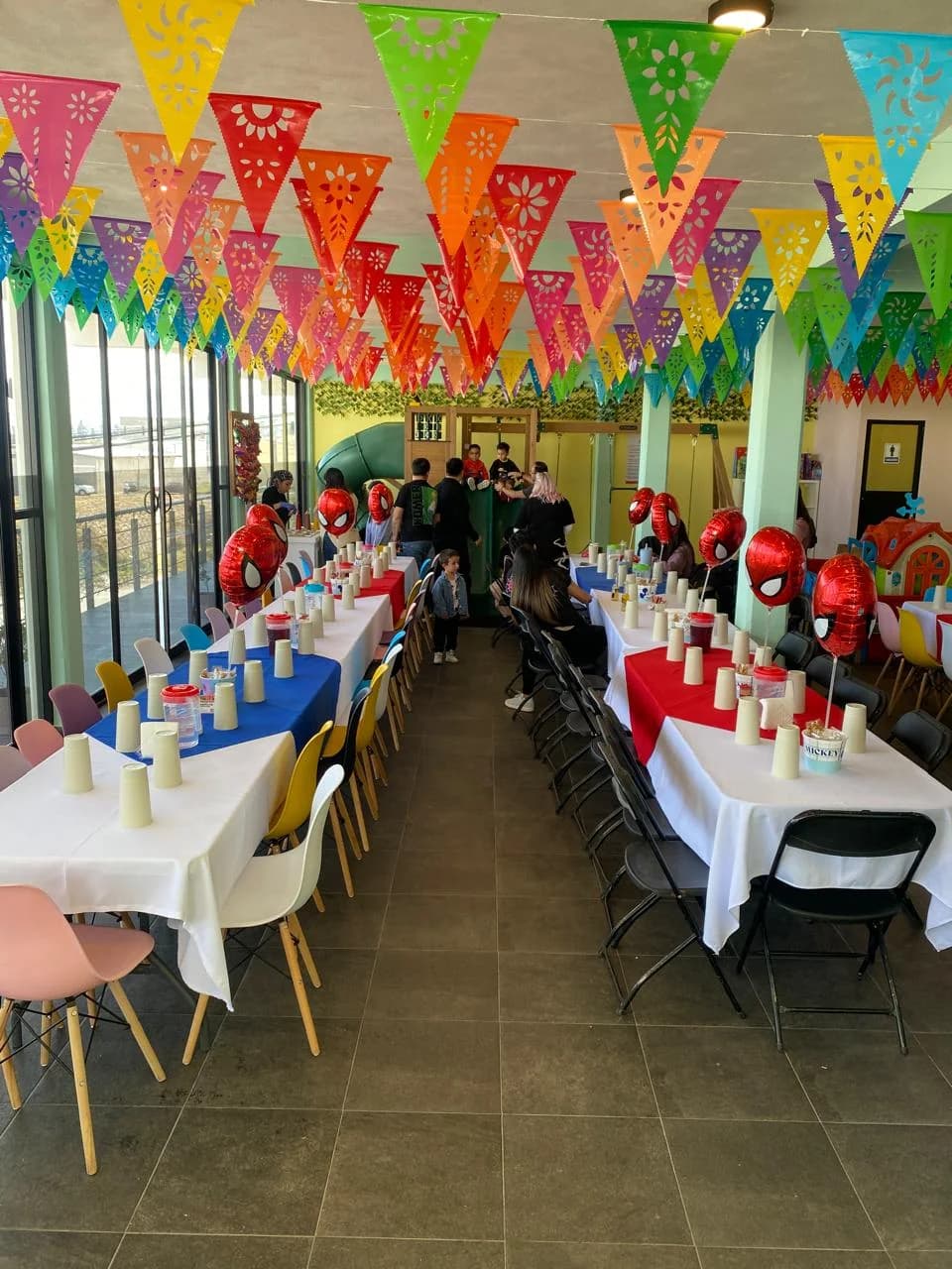 Fiesta temática en Perinolita con mesas montadas, globos y papel picado